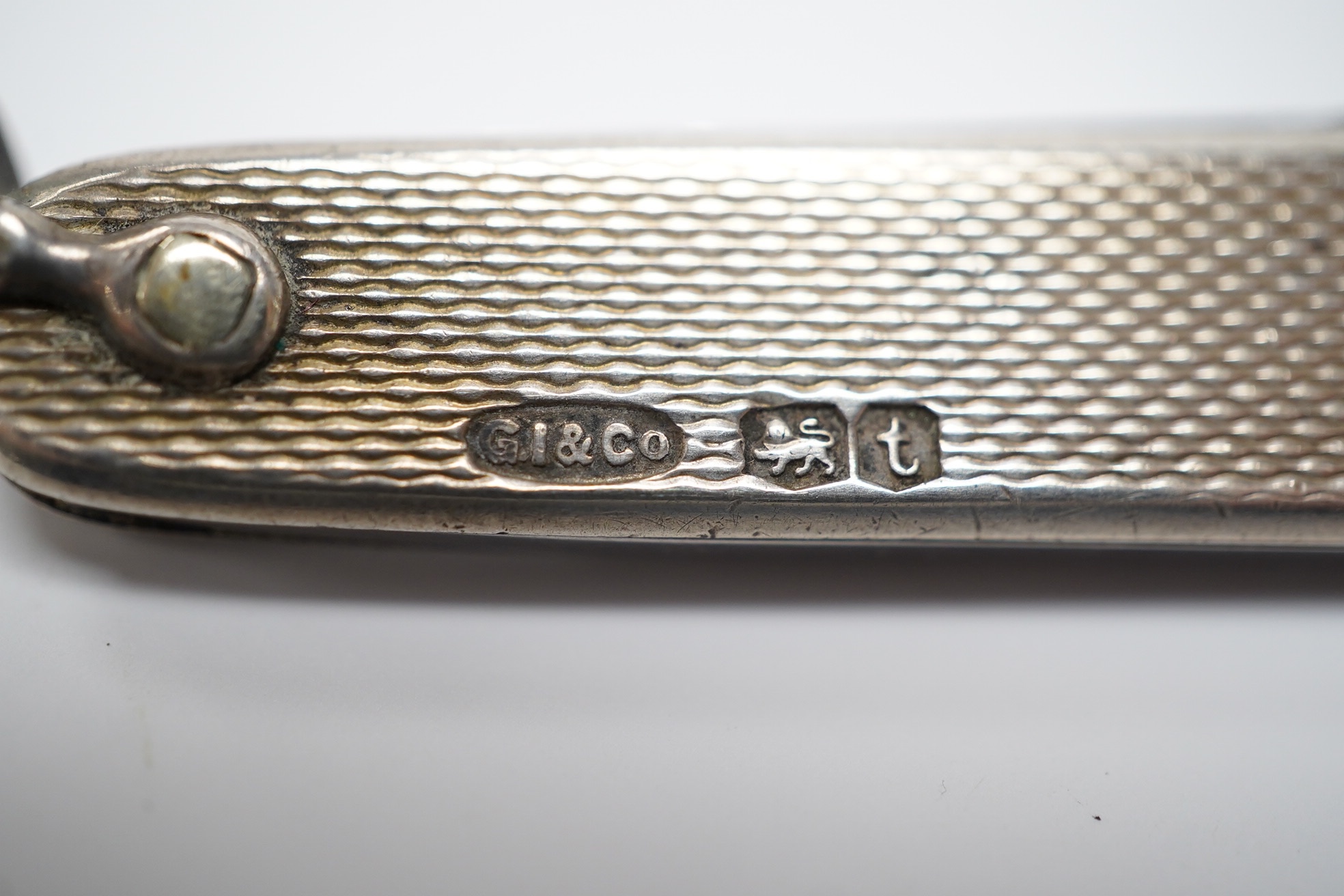 A George V engine turned silver and enamel pocket knife, decorated with R.M.S Queen Mary, the blades lifted by the handles, George Ibberson & Co, Sheffield, 1936, 76mm. Condition - poor to fair